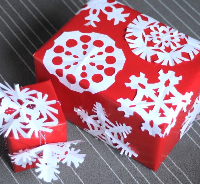 Bastelideen Winter - rote Verpackungen mit weißen Schneeflocken verziert zu Geschenken