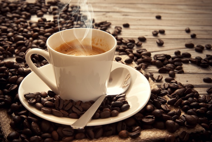 Guten Morgen Kaffee - Kaffee mit Milch auf einem hölzernen Tisch mit Kaffeebohnen darum