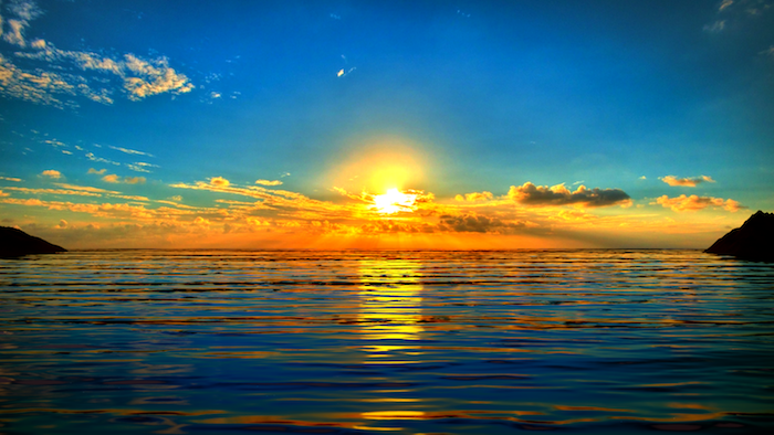 Guten Morgen Grüße - ein Sonnenaufgang über das Wasser mit kleinen Wolken