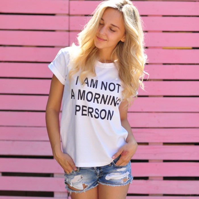 das Mädchen hat eine lustige Aufschrift auf dem T-Shirt - einen wunderschönen Guten Morgen