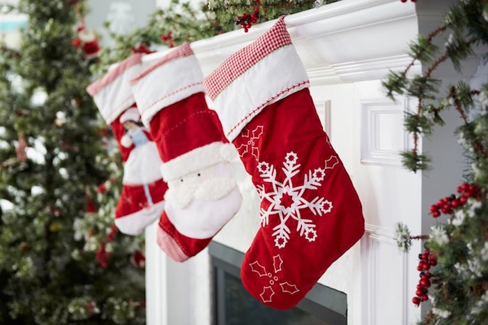 drei rote Nikolaussocken mit Wintermotiven, Socken mit Schneewittchen, Socken mit dem Weihnachtsmann, Socken mit Schneeflocken, offene Feuerstelle, aufgestellter Christbaum