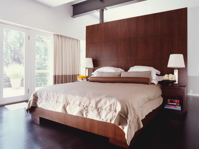 ein großes Schlafzimmer, Teenager Zimmer in brauner Farbe, viel Holz und zwei symmetrische Lampen