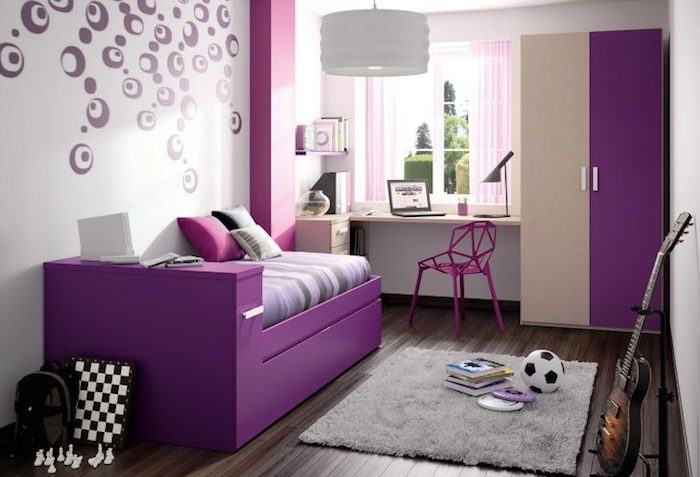 Jugendzimmer gestalten - lila Bett, kleiner grauer Teppich und zweifarbiger Schrank