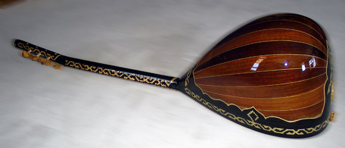 eine Bouzouki von der Rückseite, die aus einzelnen Holzbrettern mit unterschiedlichen Nuancen der Braunfarbe gefertigt wird, Kanten mit Verzierung in Goldfarbe