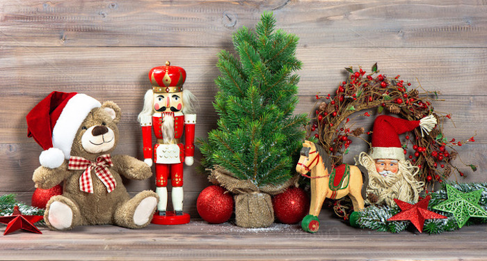 roter Weihnachtsstern, Plüschbär mit rotem Weihnachtshut mit weißem Troddel, Nussknacker aus Holz, kleiner Weihnachtsbaum, Kranz mit Mistelfrüchten, Weihnachtsmannfigur, dekorative grüne Sterne
