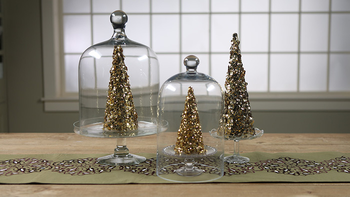 drei Tortenteller aus Glas, zwei Glasglocken, Tischläufer mit Print, drei dekorative Weihnachtsbäume mit Goldglitzer, großes Fenster mit Mattglas