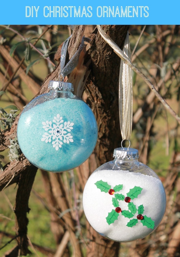Schneeflocken aus Papier verschönern einen Weihnachtskugel auf Baum gehängt