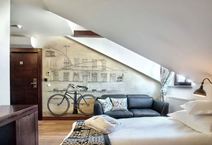 ein Zimmer für Teenager in Dachgeschosswohnung mit Fahrrad Wandtattoo, ein weißes Bett, Laminat-Boden