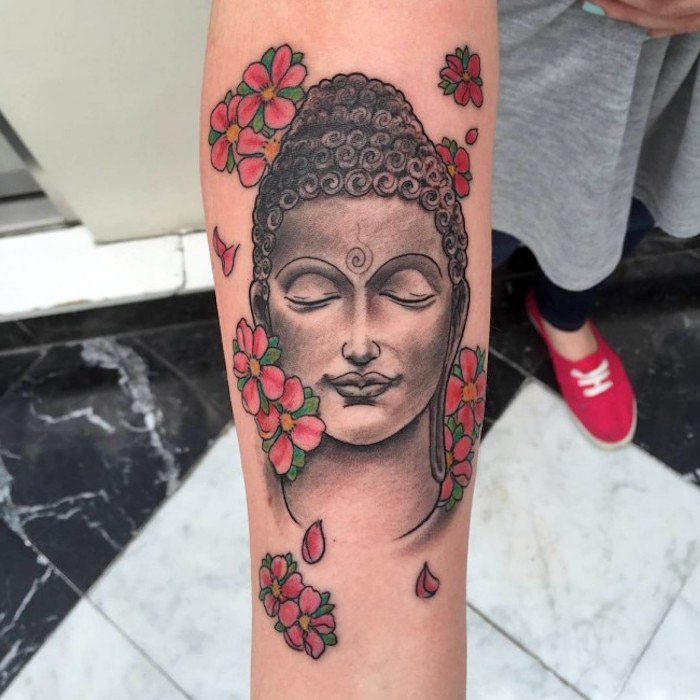 tattoos mit bedeutung, tätowierung mit buddha-motiv am unterarm, rosa kirschblüten