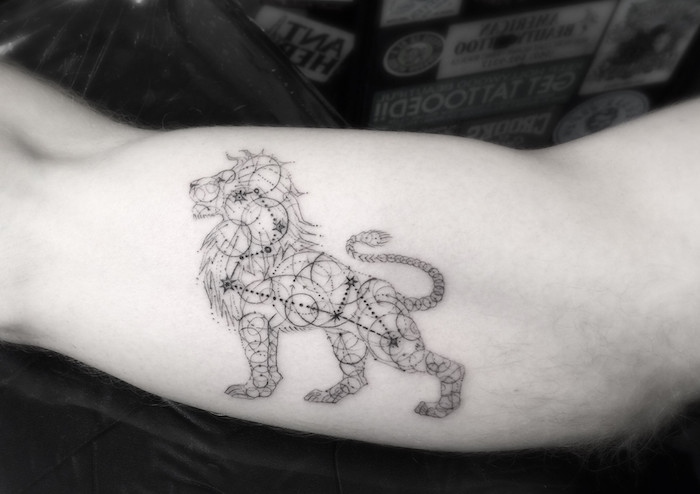 eine tattoo mit einem schwarzen löwe und einem schwarzen sternbild mit kleinen schwarzen sternen