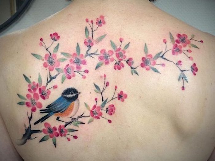 tattoo kirschblüten, rosa blüten in kombination mit vogel, tattoo am rücken