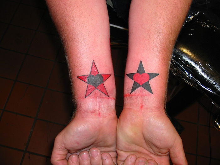 ein toter stern mit einem schwarzen herzen und ein schwarzer stern mit einem roten herzen - hände und stern tattoo