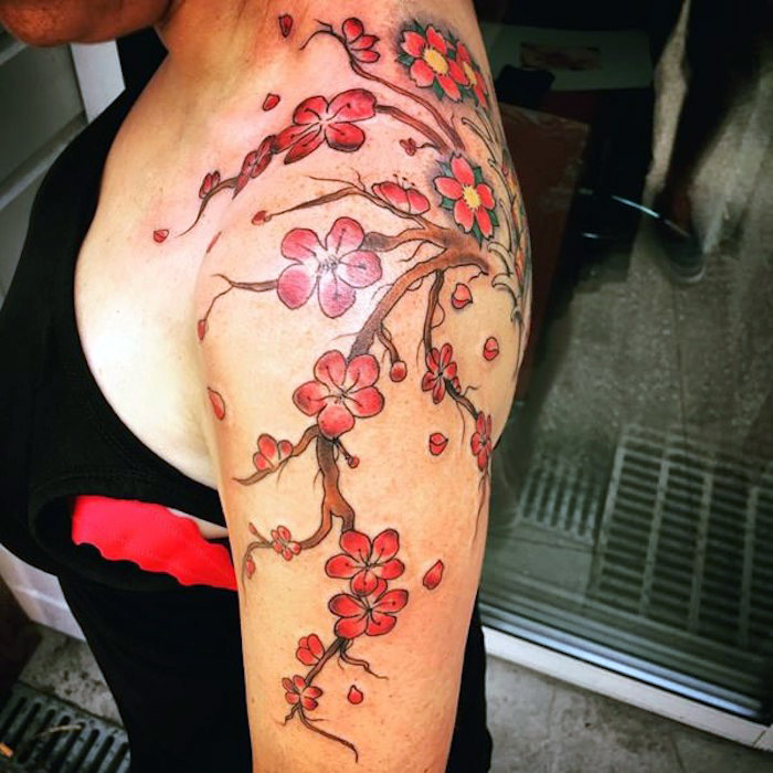 tattoos mit bedeutung, kirschbraum mit roten blüten am schulter
