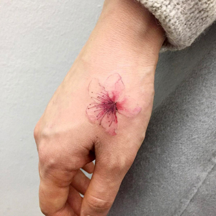 tattoos mit bedeutung, kleine tätowierung mit blumen-motiv am handgelenk