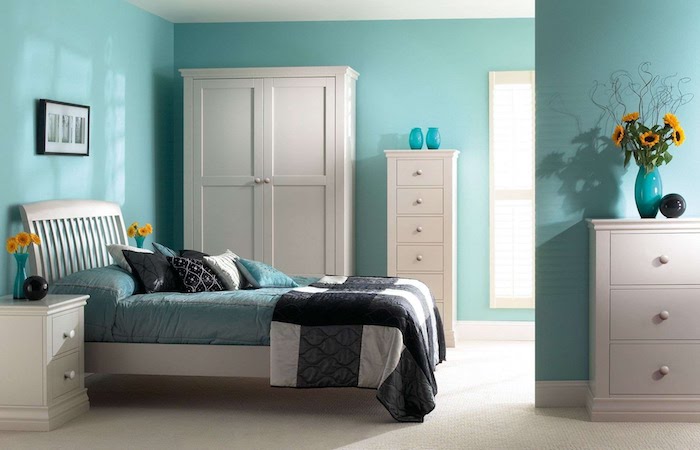schöne Zimmer mit blauen Wänden, einem weißen Schrank, bunten Bettwäschen