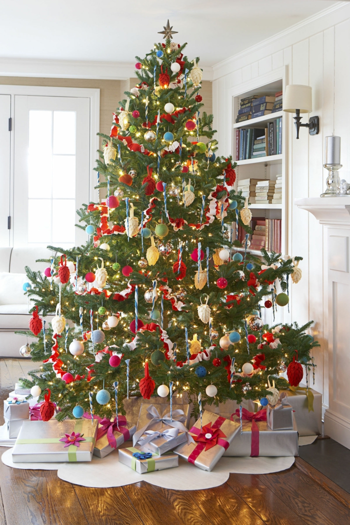 Großer Christbaum mit viel Schmuck, schön verpackte Geschenke unter dem Baum, Weihnachten zu Hause