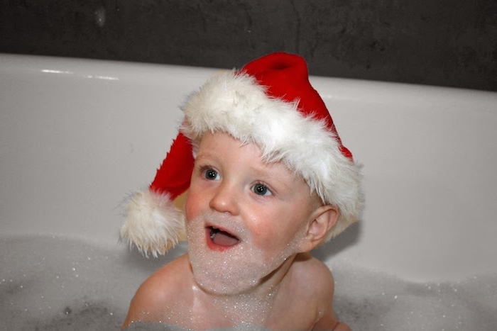 ein kleiner Weihnachtsmann mit Bart aus Schaum in der Badewanne - lustige Weihnachtsgrüße