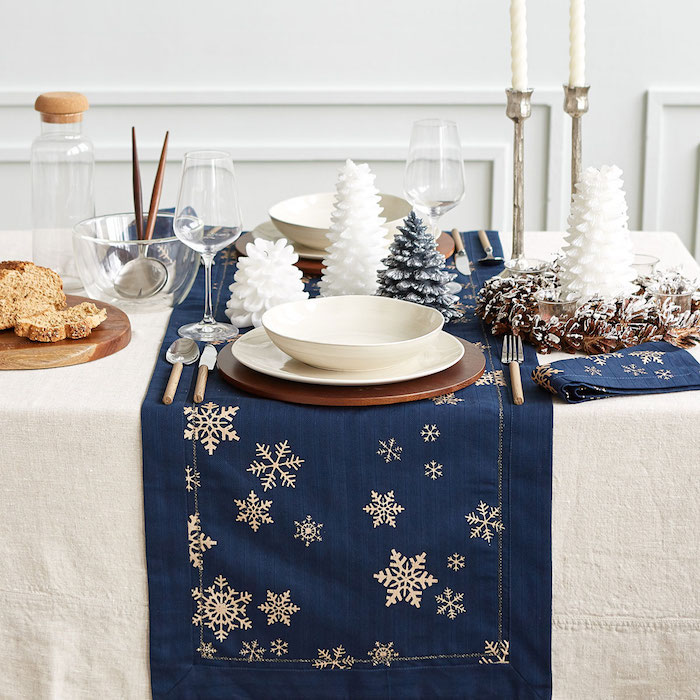 dekoideen weihnachten weiße hauptdecke mit dunkelblauen kleineen decken darauf blaue servietten und weiße schneeflocken als deko motive ideen feine weihnachtliche deko