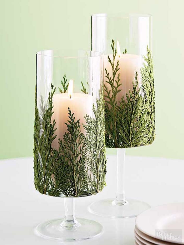 dekoration weihnachten zwei gläser mit grünen dekorativen pflanzen füllen und kerzen darin stecken