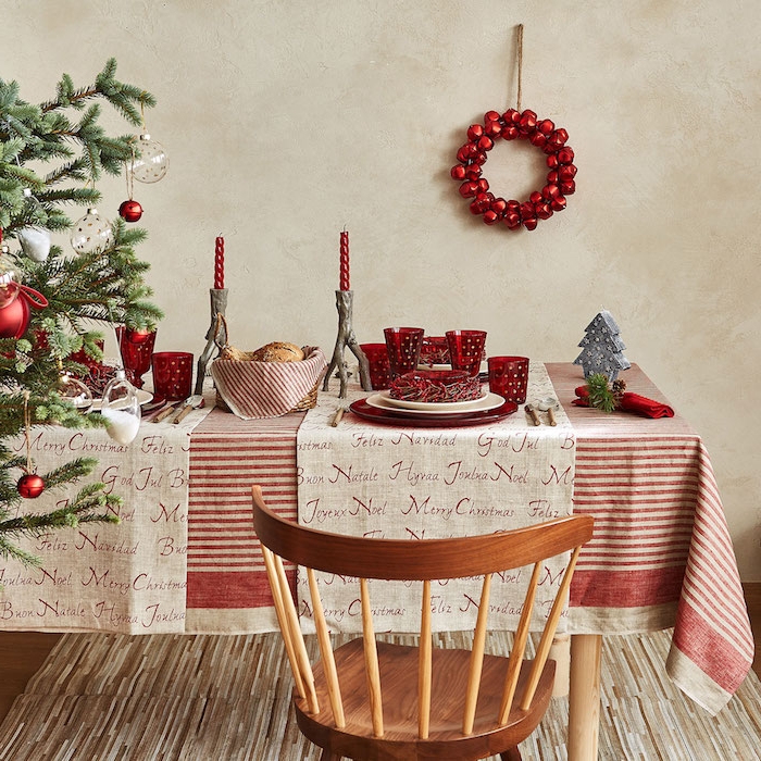 dekoideen weihnachten weihnachtliche atmosphäre roter kranz hängt an der wand weihnachtsbaum links stuhl aus holz tischdecke