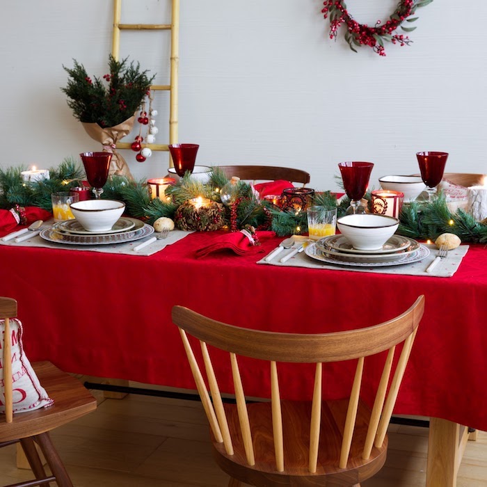 dekoideen weihnachten rote tischdecke mit grünen zweigen verziert und goldene elemente weiße geschirrelemente geschirr in weiß schüssel teller silberne geschirr