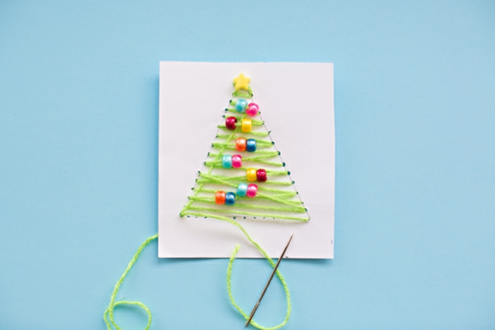 Weihnachtskarte selber basteln, Weihnachtsbaum aus grünem Garn und bunten Holzkugeln