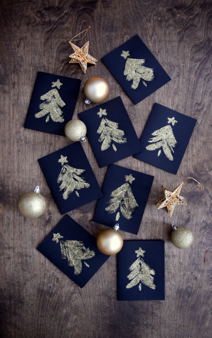 Weihnachtskarten selber basteln, goldene Christbäumchen auf schwarzem Grund, Kleber auftragen, mit Glitzer besprühen