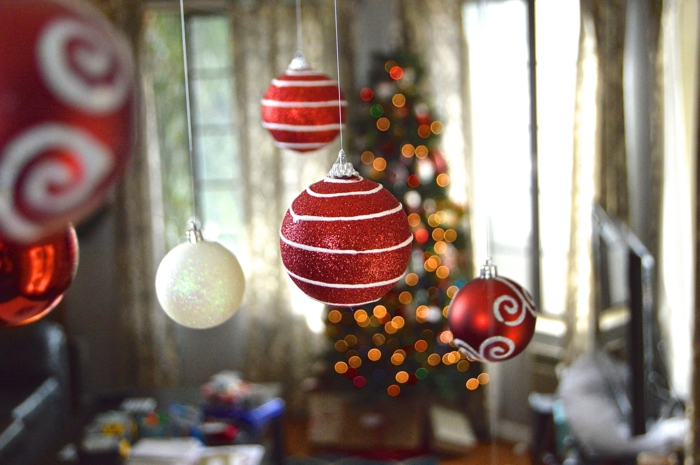 Weiße und rote Weihnachtskugeln mit Glitzer besprüht, an der Decke aufgehängt, Idee für Weihnachtsdekoration