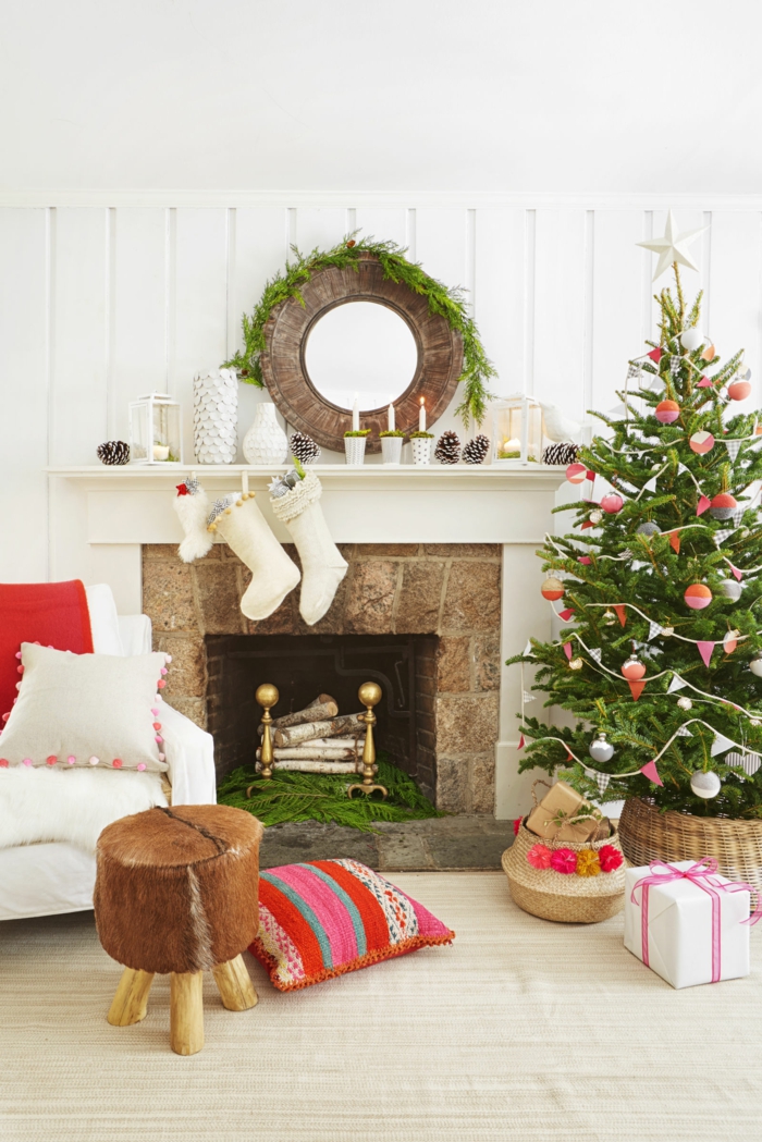 Weihnachtsdekoration im Wohnzimmer, Christbaum schön geschmückt, weiße Strümpfe am Kamin, Weihnachtskranz und Kerzenhalter