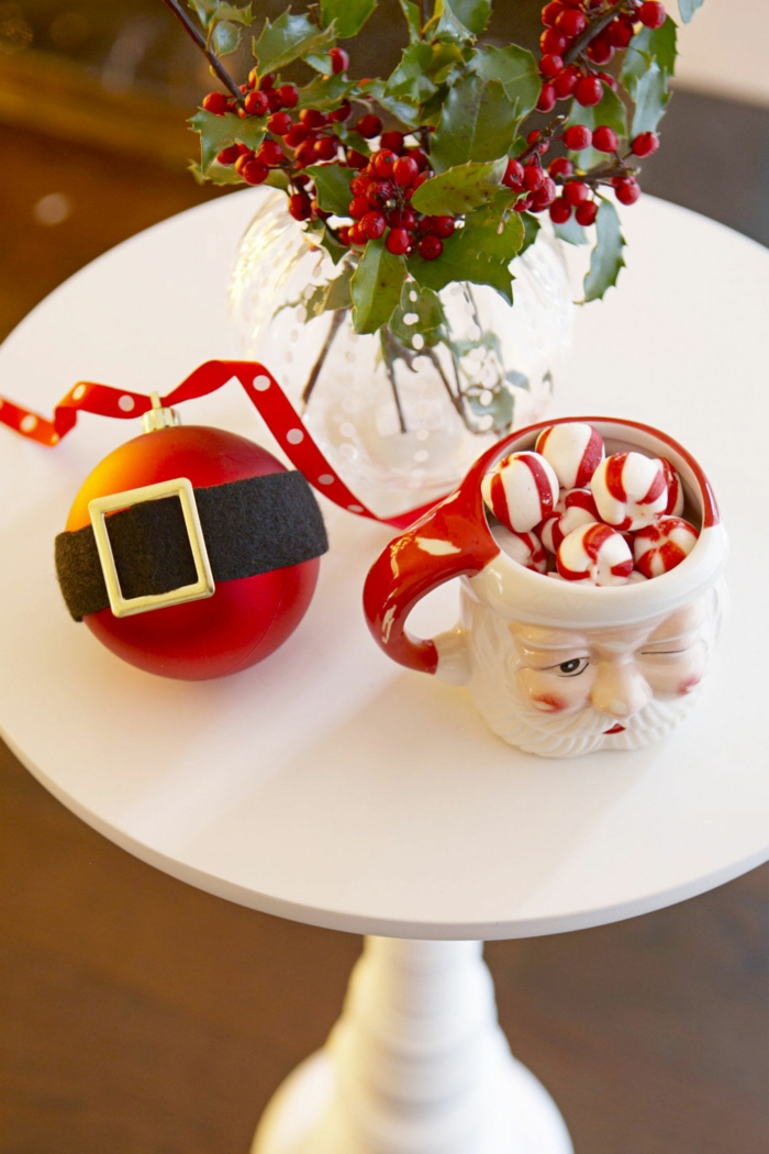 Idee für Weihnachtstischdekoration, Mistel in Glasvase, Weihnachtskugel mit Gürtel und Teetasse als Weihnachtsmann