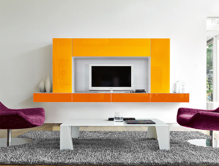 wohnwand modern wandgestaltung gelb und orange lila sessel grauer teppich weißer tisch