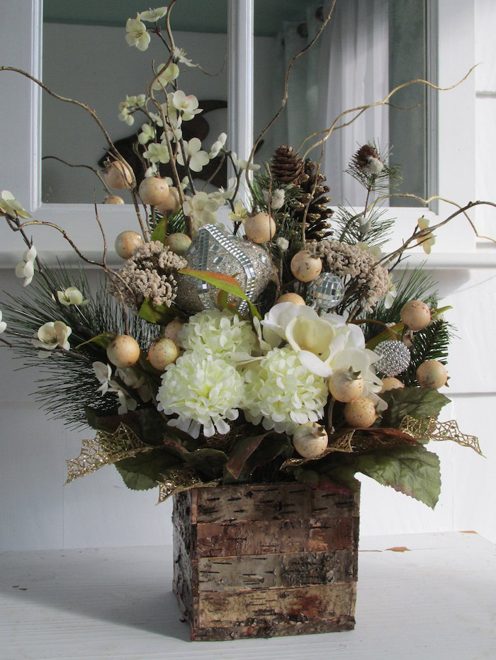 Weihnachtsgestecke eine Vase aus Holz, weiße Blume, silberne Weihnachtskugeln