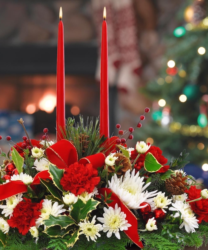 Weihnachtsdeko Hauseingang - zwei Kerzen in roter Farbe, weiße und rote Blumen