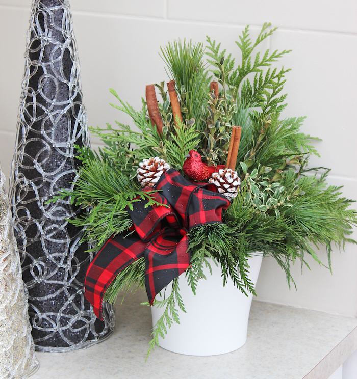 Weihnachtsdeko Hauseingang - eine weiße Vase, rote Schleife, Zimtstangen