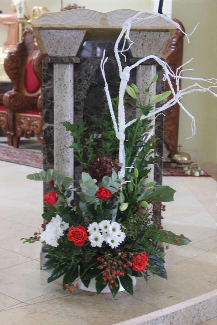 Adventsgesteck selber machen - rote und weiße Blumen, grüne Blätter auf einer Kaminkonsole