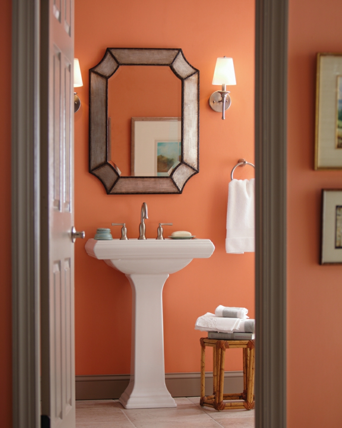 Badezimmer in Apricot, Spiegel mit silbernem Rahmen, weißer Waschbecken, Wandfarbe Apricot