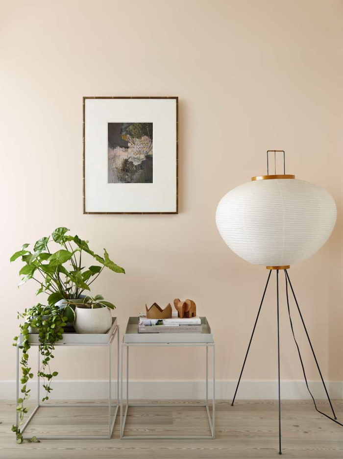 Wandfarbe Apricot, Gemälde an der Wand, grüne Zimmerpflanzen, Holzfiguren Elefant und Krone