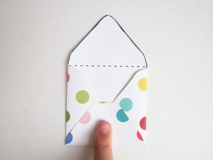 Briefumschlag basteln - einen weißen Briefumschlag mit vielen bunten Flecken