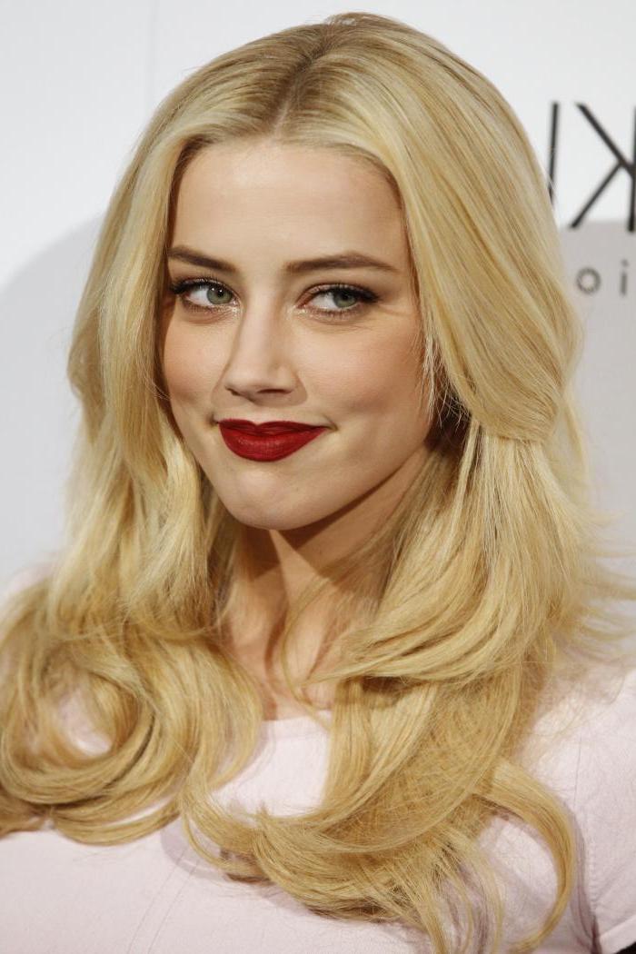 ein Schauspielerin mit langen blonden Haaren, rosa Bluse und weinrotem Lippenstift - schöne Haarfarbe