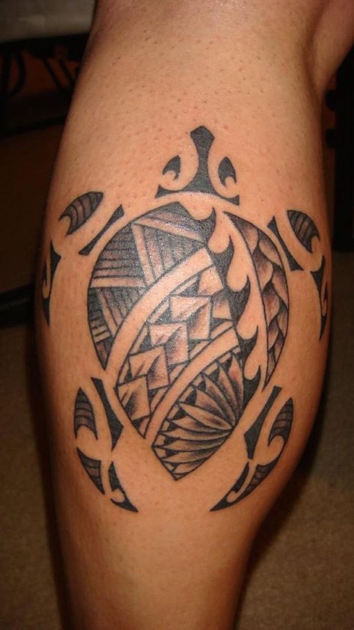 eine große schwarze schildkröte mit schwarzen augen - ein bein mit einem schwarzen maorie tattoo