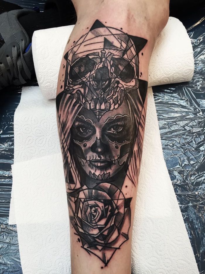 ein großer schwarzer tattoo mit einem weißen großen schädel, einer junger frau und einer rose - bedeutung la catrina