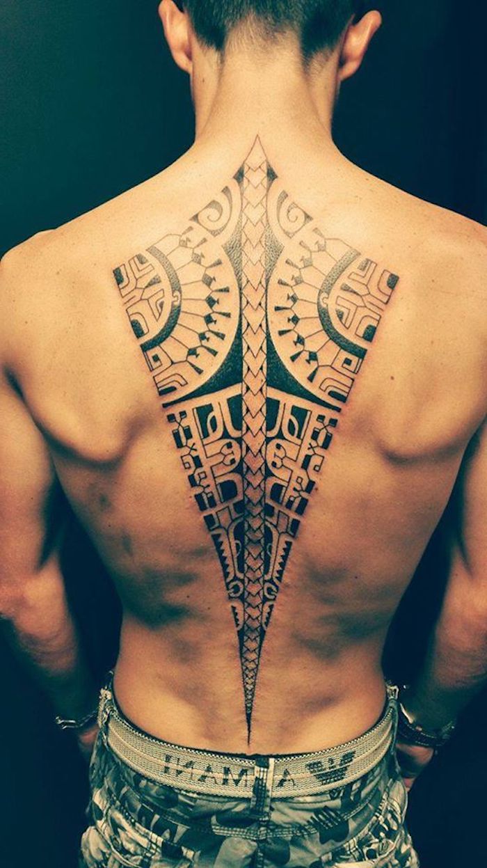ein großer schwafrzer maori tattoo mit maori tattoo motiven - ein junger mann mit einer schwarzen tätowierung auf dem rücken