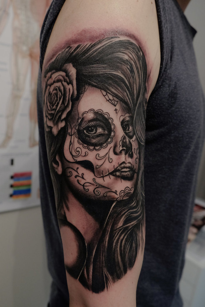 mann mit einem la catrina tattoo mit einer weißen rose und einer verstorbenen jungen frau mit schwarzen lippen