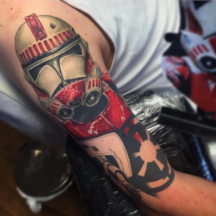 ein mann mit einer hand mit einem star wars tattoo mit einem roten roboter und einem kleinen schwarzen star wars tattoo