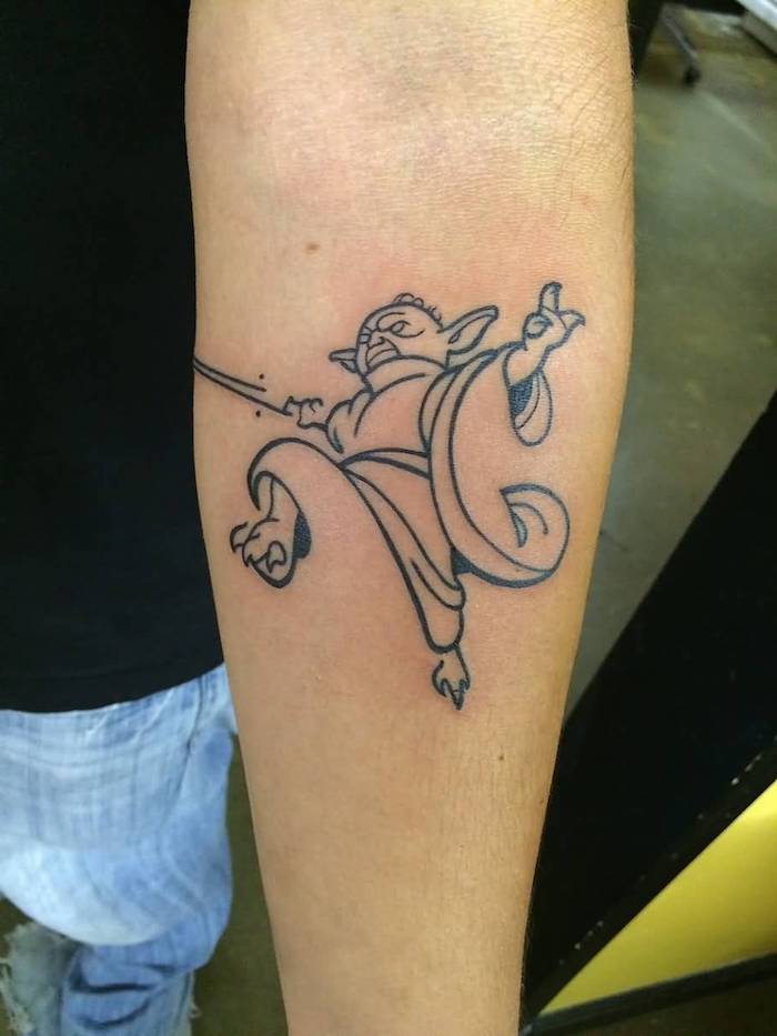 hier ist eine hand mit einem kleinen winzigen star wars tattoo mit einem schwarzen tattoo mit einem jedi - joda mit seinem kleinen lichtschwert