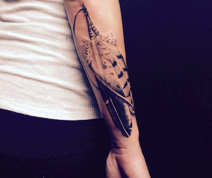 federn tattoo am unterarm, schwarz-graue tätowierung mit indianischem motiv