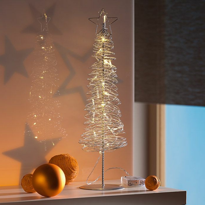 Tannenbaum aus Metalldrahtmit kleinen Lampen und einen Weihnachtsbaumstern an der Spitze, ein großer Kugel mit Goldüberzug, drei gelbe Weihnachtsbaumkugeln, Fensterrollo in grauer Farbe