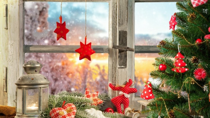 aufgestellter Tannenbaum mit roten Weihnachtsdekorationen aus Stoff, Weihnachtsbäume aus rotem Stoff mit weißen Punkten, Tannenbaum mit Lichterkette, Dekoelement in der Form eines Herzens, Deko-Herz aus kariertem Stoff, Latenr mit Metalldeckel, rote Weihnachtssterne am Fenster