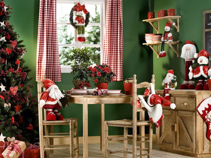 fensterdeko zu weihnachten weihnachtskranz mit einem schneemann sitzend darauf stühle weihnachtsmann hölzerne möbel