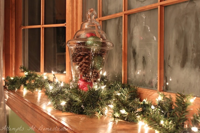 fensterdeko ideen winterliche atmosphäre zweige lichtkette fenster zapfen weihnachtsbälle dekorationen 